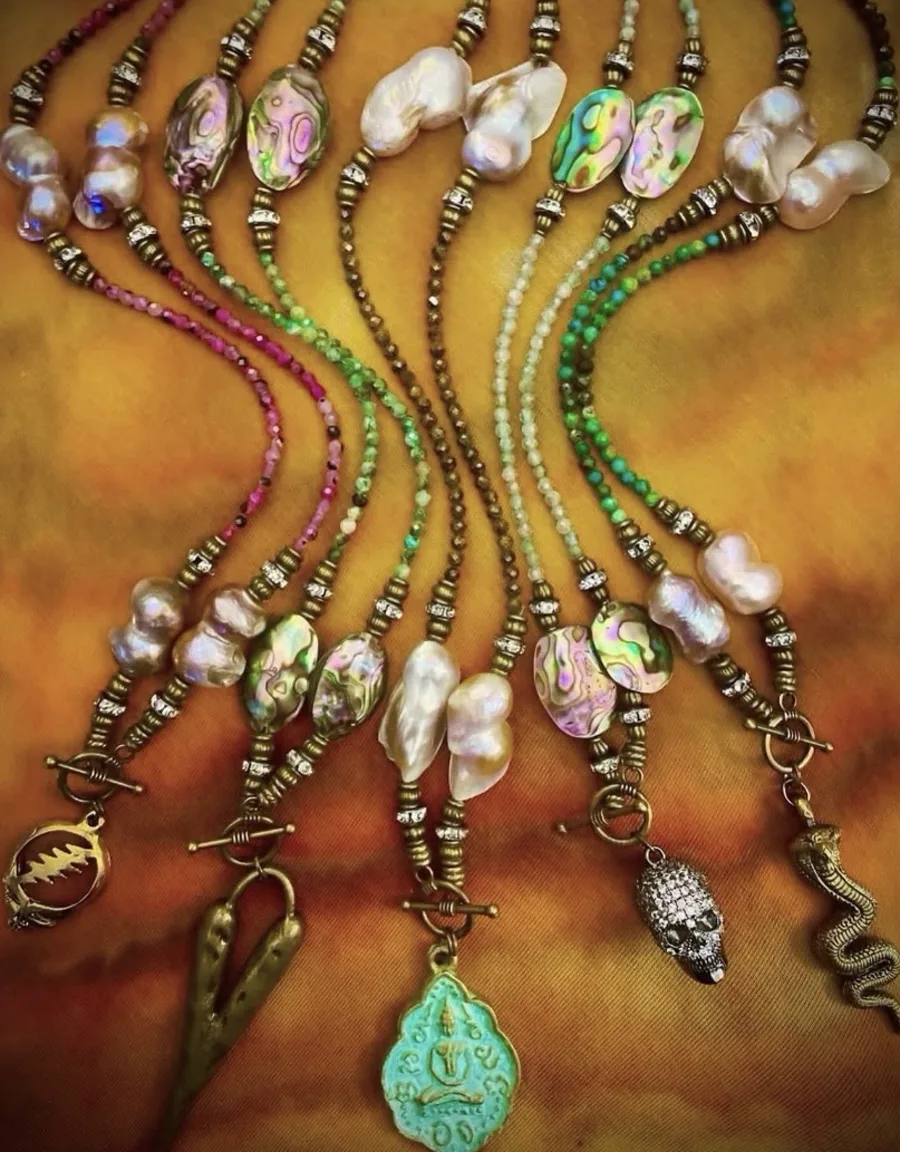 Colorful pearl and gemstone lovebeads on golden fabric